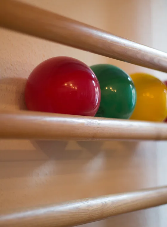 Bunte Gymnastikbälle auf der Ablage einer Sprossenwand